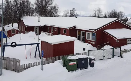Amaliahaugen barnehage og uteområde med husker og leketårn en snørik vinterdag 
