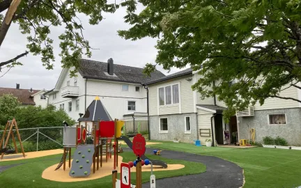 Bamsestua friluftsbarnehage uteområde Bamsestua friluftsbarnehage uteområde med lekeapparater en grå sommerdag