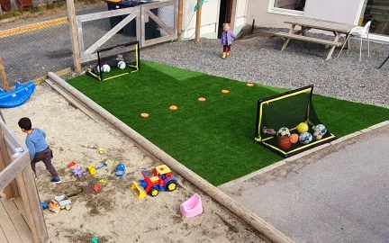 Dalen familiebarnehage uteområde Uteområde i Dalen familiebarnehage med fotballbane i kunstgress, benker og bord og sandkasse