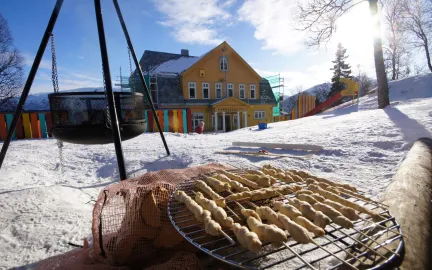 Grilling av pinnebrød uten for barnehagen en solrik vinterdag