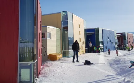 Storvollen barnehages uteområde sett utenfra en vinterdag med snø og blå himmel
