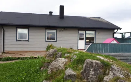 Trondjord barnehage sett utenfra med grønt gress en grå sommerdag 