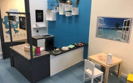 Inneområde med lekekjøkkenkrok bord og stoler