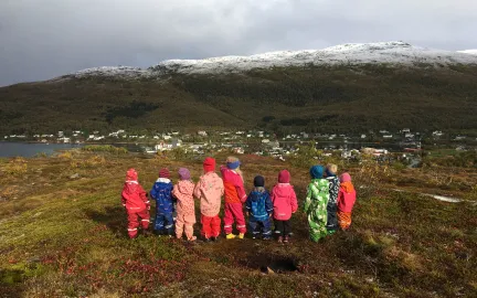 Lekestua familiebarnehage Ti barnehagebarn som står på en topp på tur en tidlig høstdag