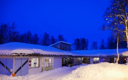 Norrøna barnehage sett utenfra en snørik vinterdag i blåtimen