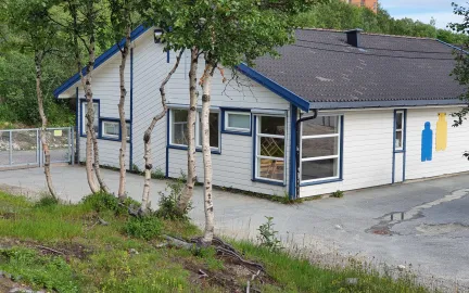 Soldagen barnehage sett utenfra med skog og grønt gress en sommerdag