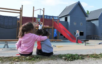 Strandkanten FUS barnehage To jenter holder rundt hverandre i uteområdet ved Strandkanten FUS barnehage