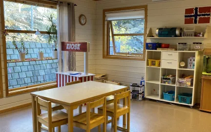 Inneområde med kiosk, bord og hyller i Toftveien barnehage