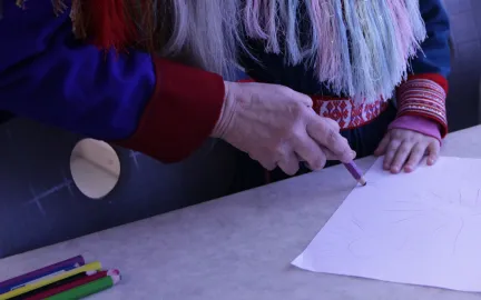 Barn og voksen tegner sammen i den samiske basen i Gimle studentbarnehage