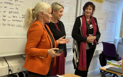 Rektor ved voksenopplæringen Lena Steinsvik Hansen, arbeids- og inkluderingsminister Marte Mjøs Persen og språklærer Marit Næsvoll foran språkklassen står fremst i klasserommet under norskopplæringen for innvandrere