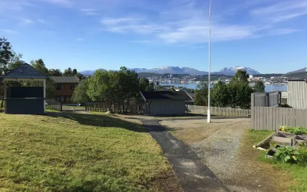 Uteområde Kroken barnehage med utsikt mot Tromsøya en solrik sommerdag