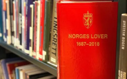 Rød bok med påskriften Norges lover