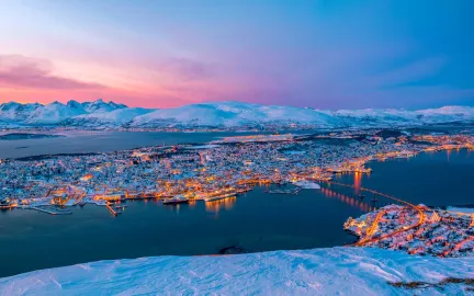 Panoramabilde av et snøkledt Tromsøya tatt fra fjellheisen i Tromsdalen.