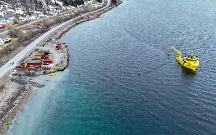 Dronebilde av sjøledning som kobles til på land.