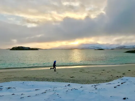 Gutt løper på strand vinter Gutt løper på strand vinter