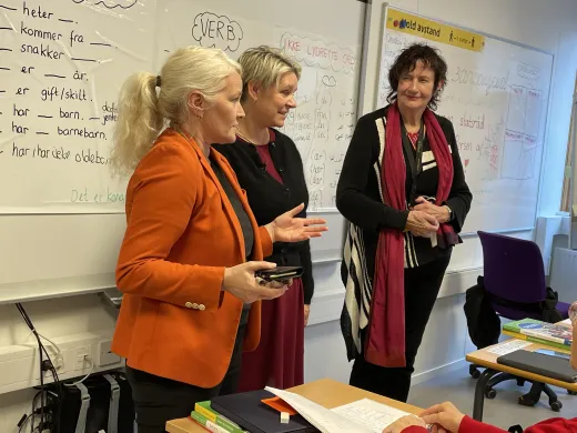 Rektor ved voksenopplæringen Lena Steinsvik Hansen, arbeids- og inkluderingsminister Marte Mjøs Persen og språklærer Marit Næsvoll foran språkklassen står fremst i klasserommet under norskopplæringen for innvandrere