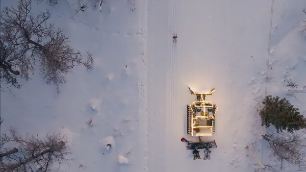 Dronefoto av tråkkemaskin og skiløper.
