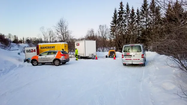 Flere biler og utstyr er parkert nært kum hvor arbeid skal utføres.