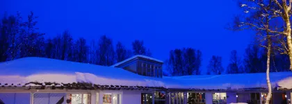 Norrøna barnehage sett utenfra en snørik vinterdag i blåtimen