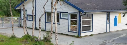 Soldagen barnehage sett utenfra med skog og grønt gress en sommerdag